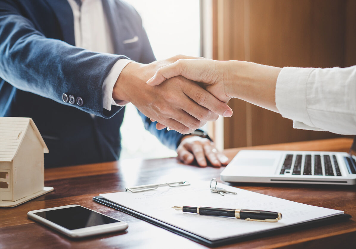 Real estate agent and customers shaking hands together celebrating finished contract after about home insurance and investment loan, handshake and successful deal.